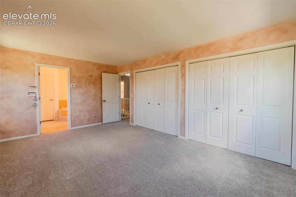Image 39 of 47: Plush carpeting, multiple bi-fold closet doors, and textured wall finishes