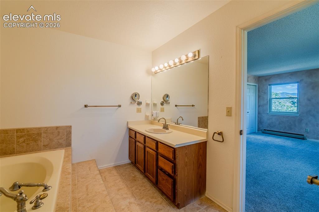 Image 40 of 47: Built-in bathtub with tiled surround
