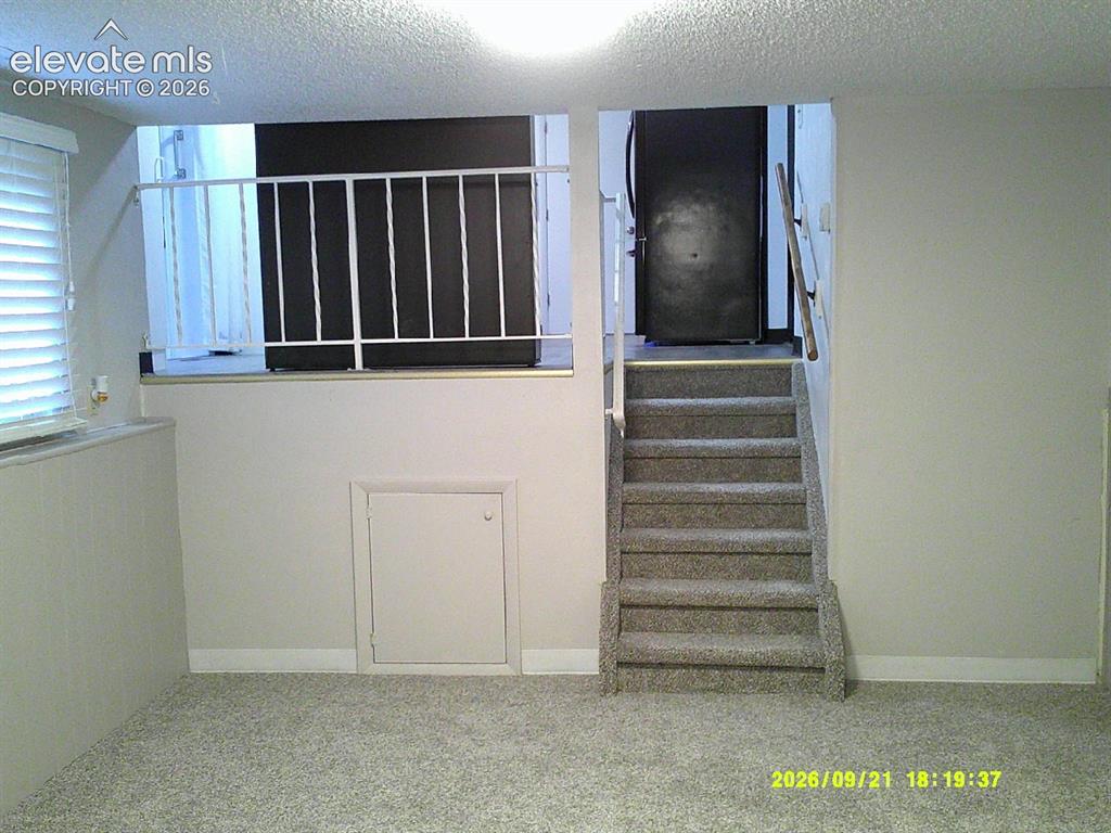 Image 15 of 26: Carpeted flooring with a white railing and a window with blinds
