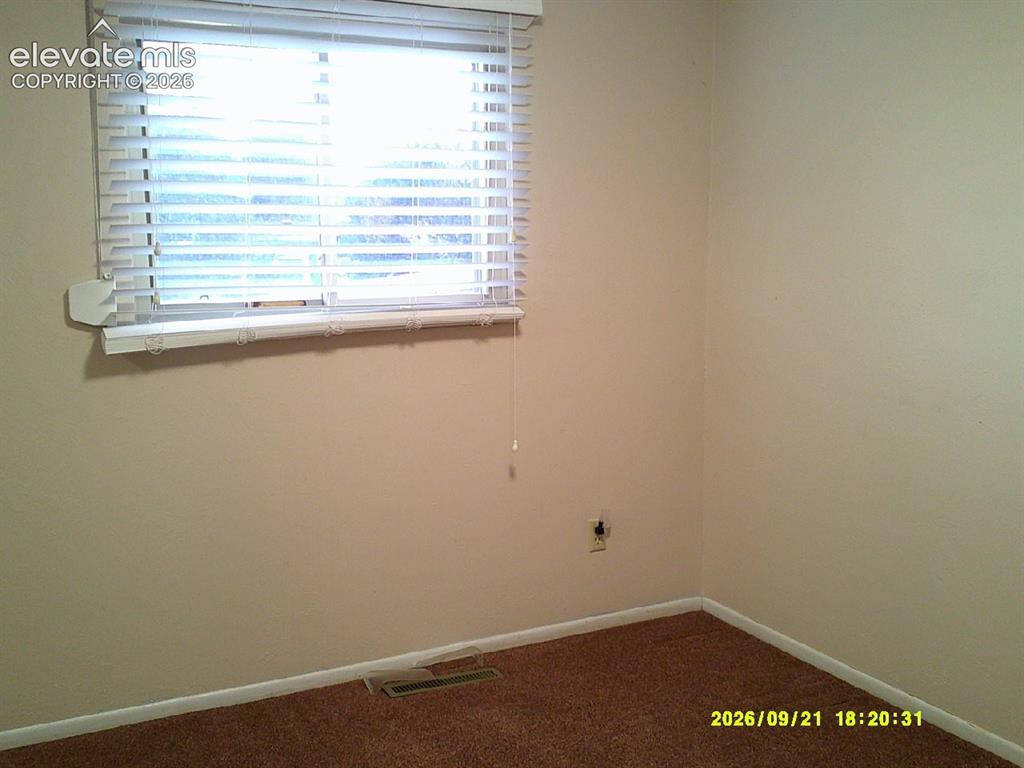 Image 18 of 26: Neutral-toned walls with a window featuring horizontal blinds