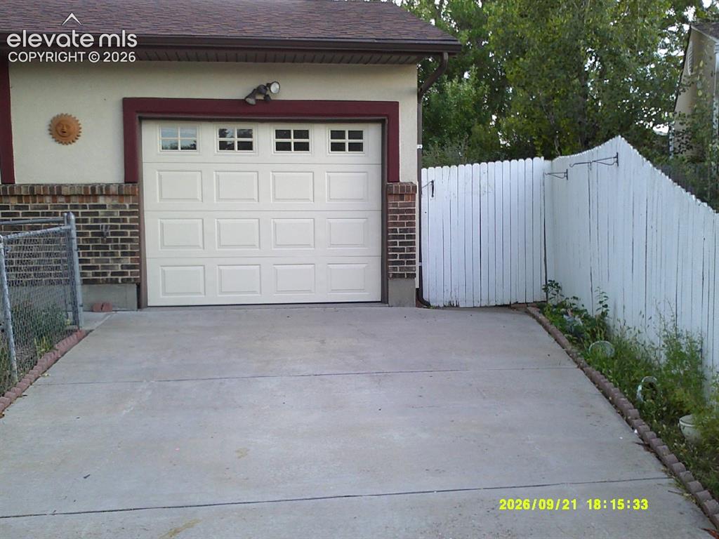 Image 4 of 26: Attached garage with panel door and upper lites