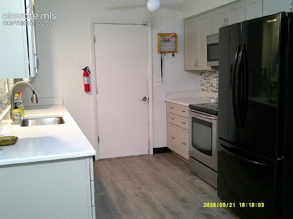 Image 9 of 26: Kitchen featuring light cabinetry, white countertops, a stainless steel sin