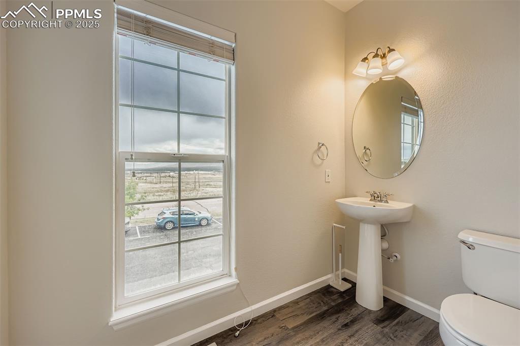 Image 11 of 27: Half bath featuring healthy amount of natural light and dark wood-style flo