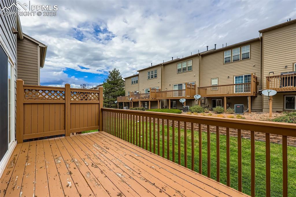 Image 13 of 27: Wooden terrace with a lawn and a residential view