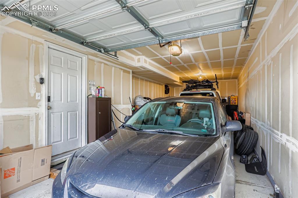 Image 14 of 27: Garage featuring a garage door opener