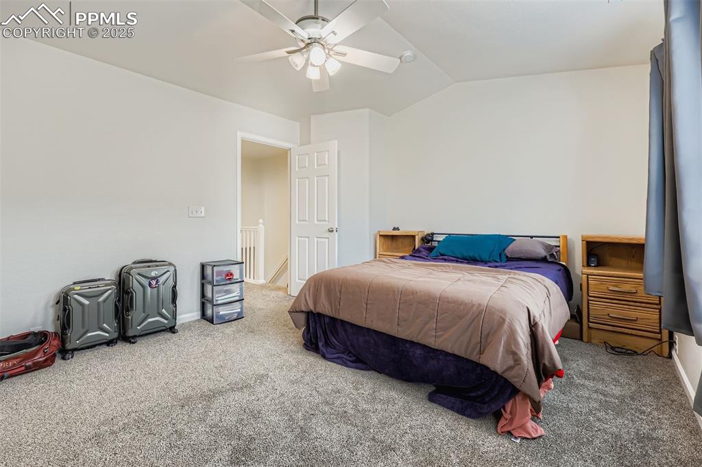 Image 17 of 27: Bedroom with carpet flooring, lofted ceiling, and a ceiling fan