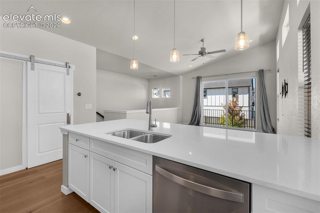 Image 13 of 34: Kitchen featuring an expansive center island with solid-surface countertops