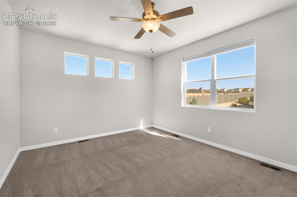Image 14 of 34: Neutral-toned room featuring wall-to-wall carpeting, three high-set square