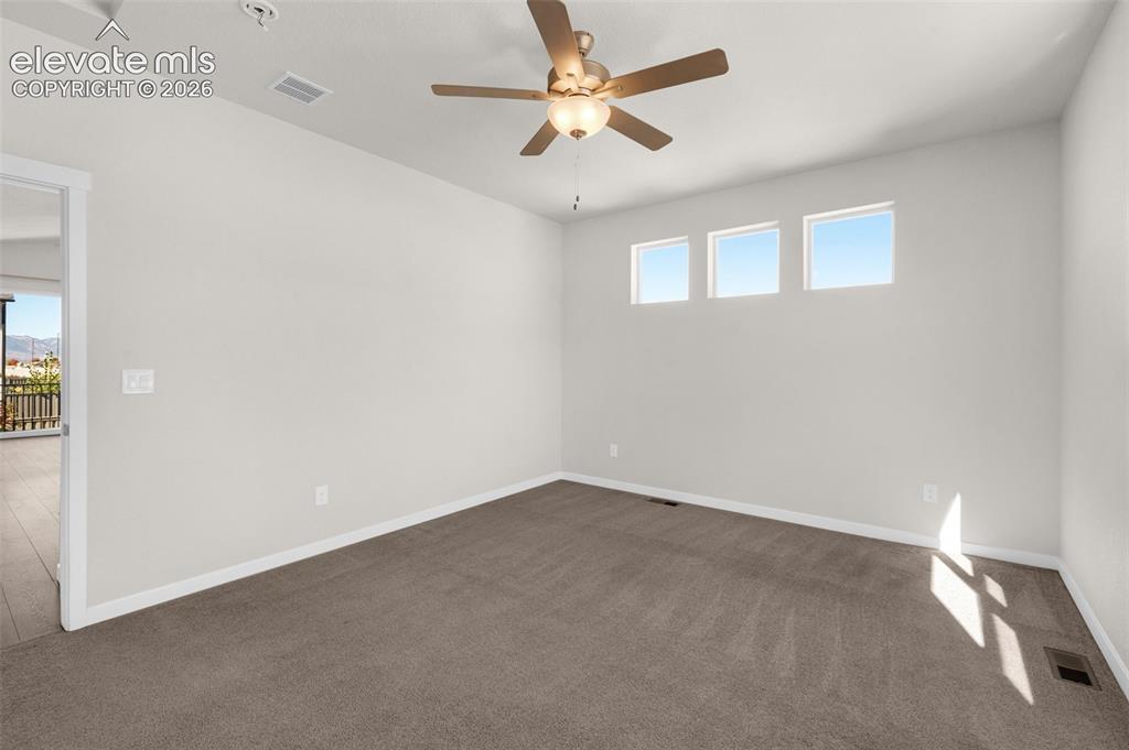 Image 15 of 34: Neutral-toned interior space featuring three high-placement windows, carpet