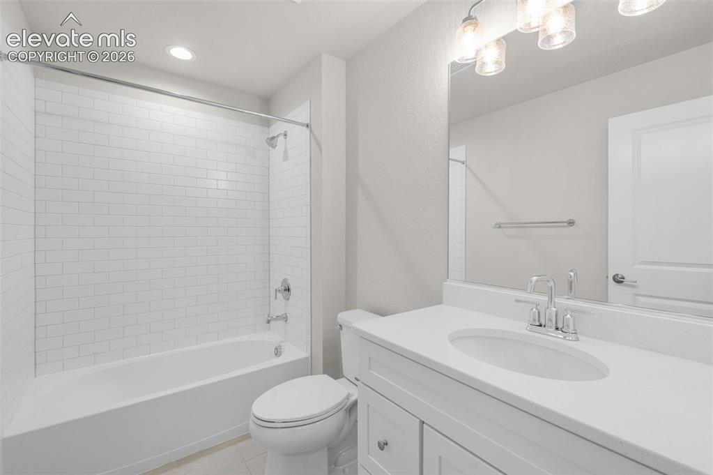 Image 23 of 34: Bathroom featuring a white vanity with a composite countertop, an oval unde