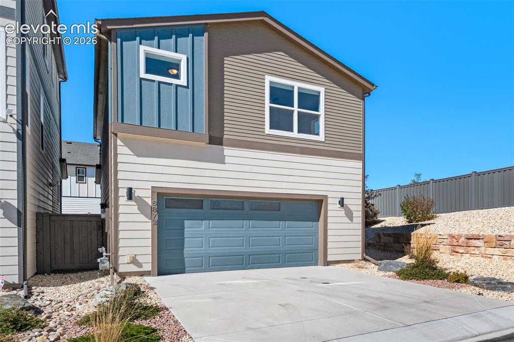 Image 27 of 34: Multi-level exterior featuring horizontal and vertical lap siding, an attac