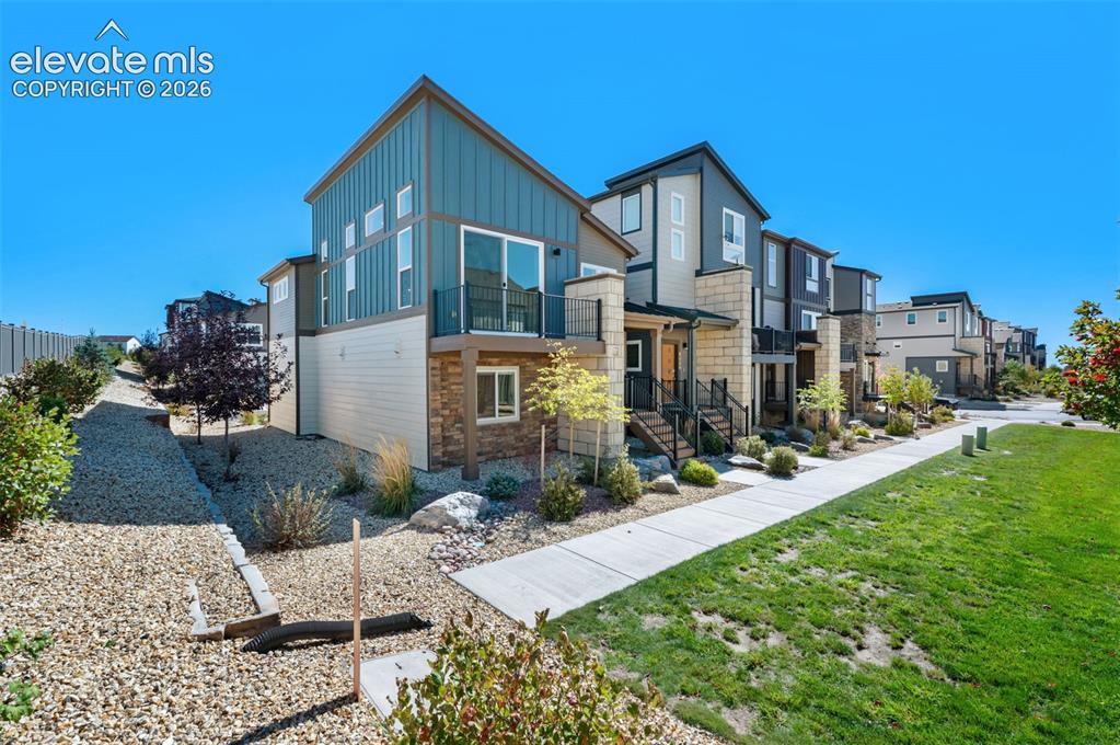 Image 3 of 34: Contemporary exterior featuring vertical metal siding, stacked stone masonr