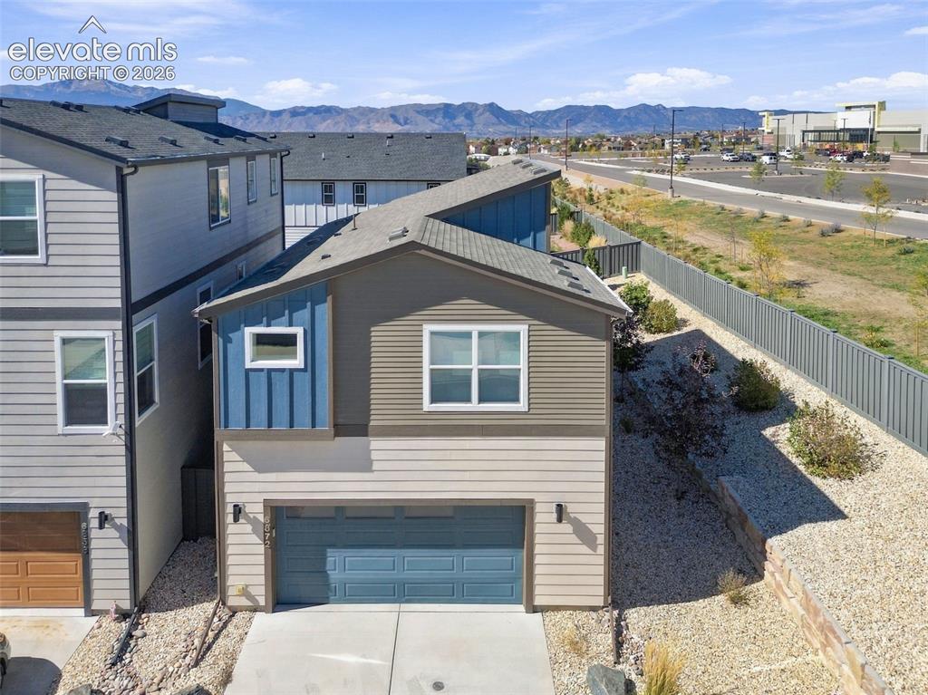 Image 32 of 34: Two-story residence featuring multi-tone horizontal siding, vertical paneli