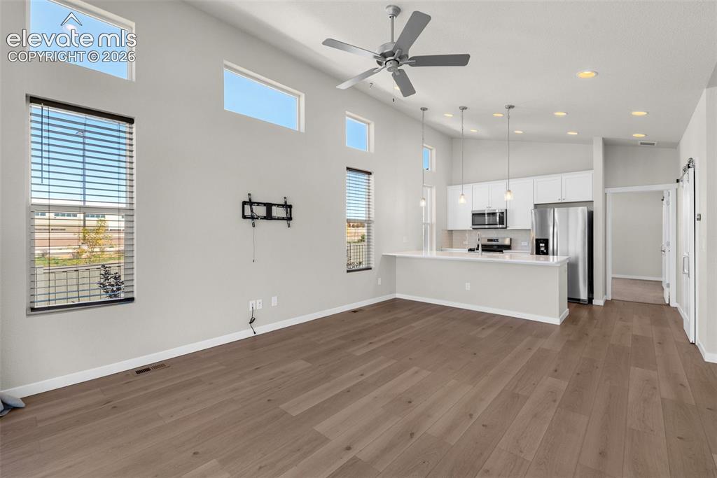 Image 5 of 34: High vaulted ceilings with recessed lighting, wood-finish flooring, multi-l