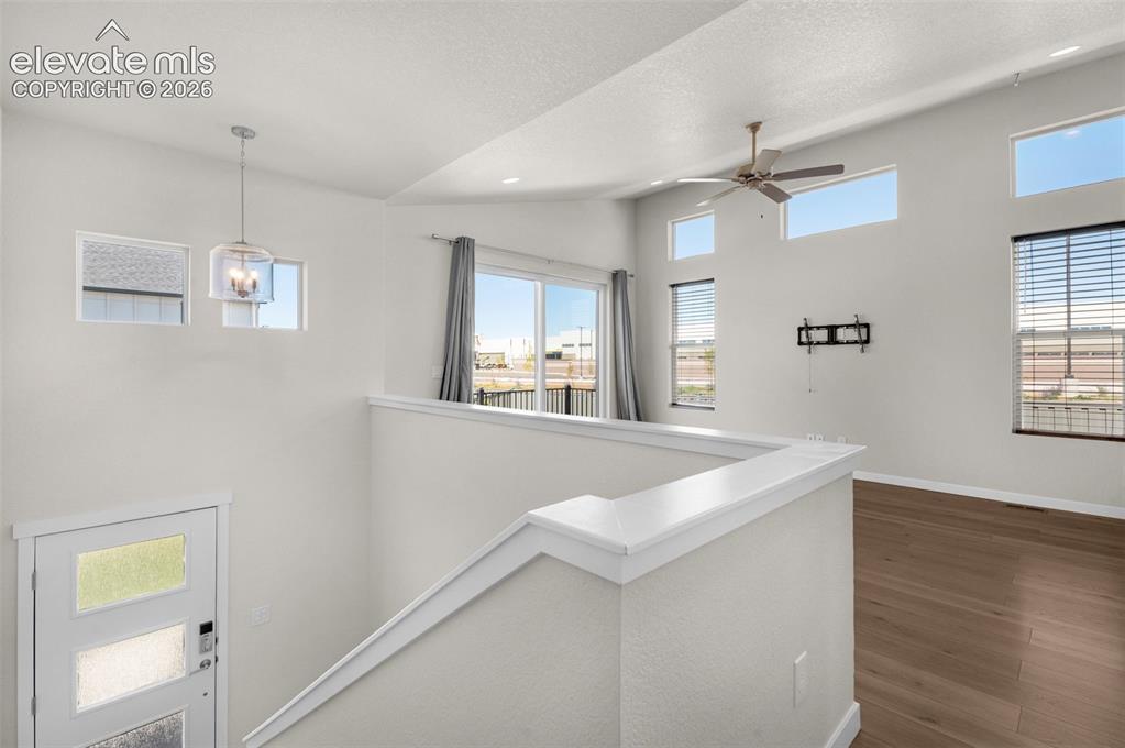 Image 9 of 34: Vaulted ceilings, wood-finish flooring, multi-level windows, modern pendant