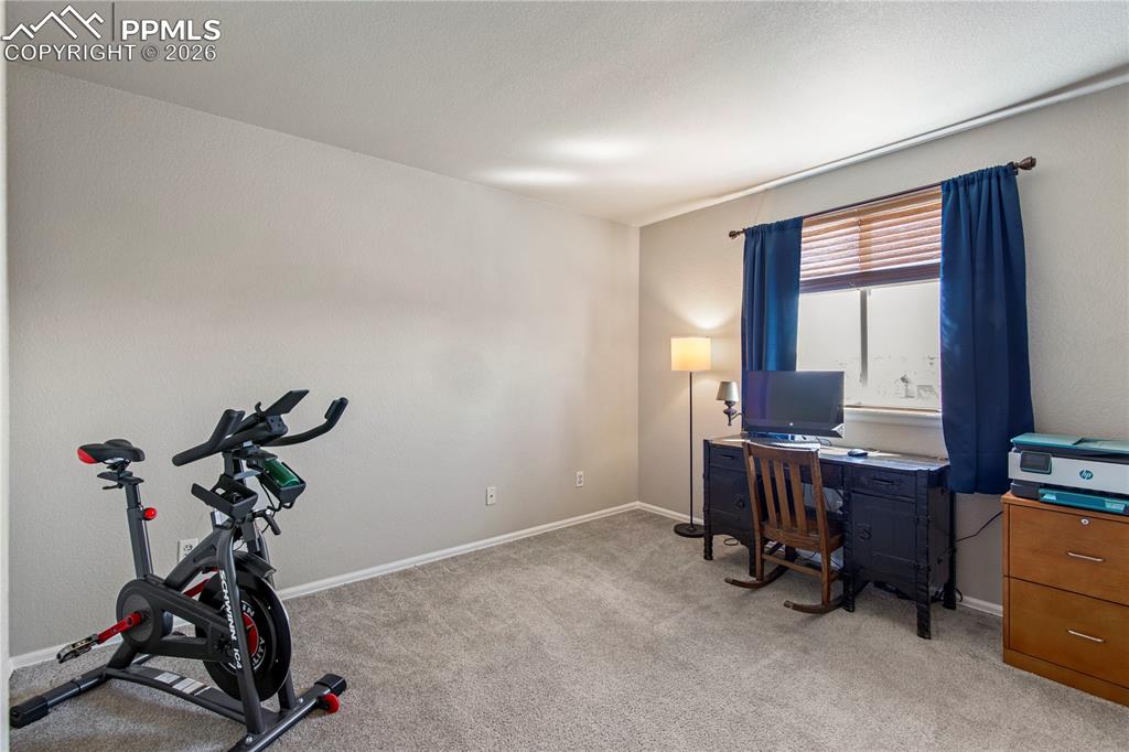 Image 16 of 27: Bedroom #4 upstairs is currently used as an office/exercise room