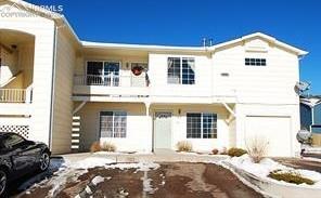 Caption: Two-story multi-unit dwelling with light-colored siding