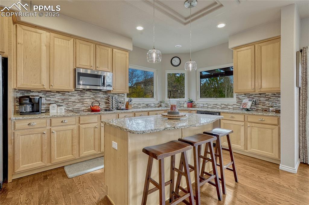 Image 17 of 48: Kitchen features slab granite countertops hardwood floors, s/s appliances..
