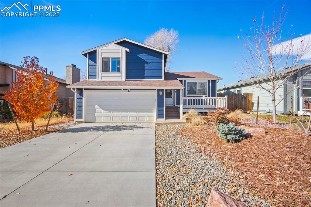 Caption: View of front of house featuring an attached garage, concrete driveway, and roof with shingles