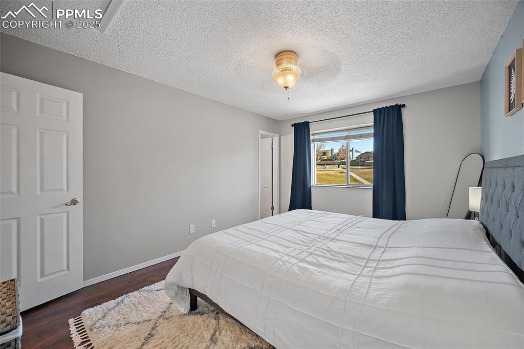 Image 17 of 50: Bedroom with dark wood-type flooring and a textured ceiling