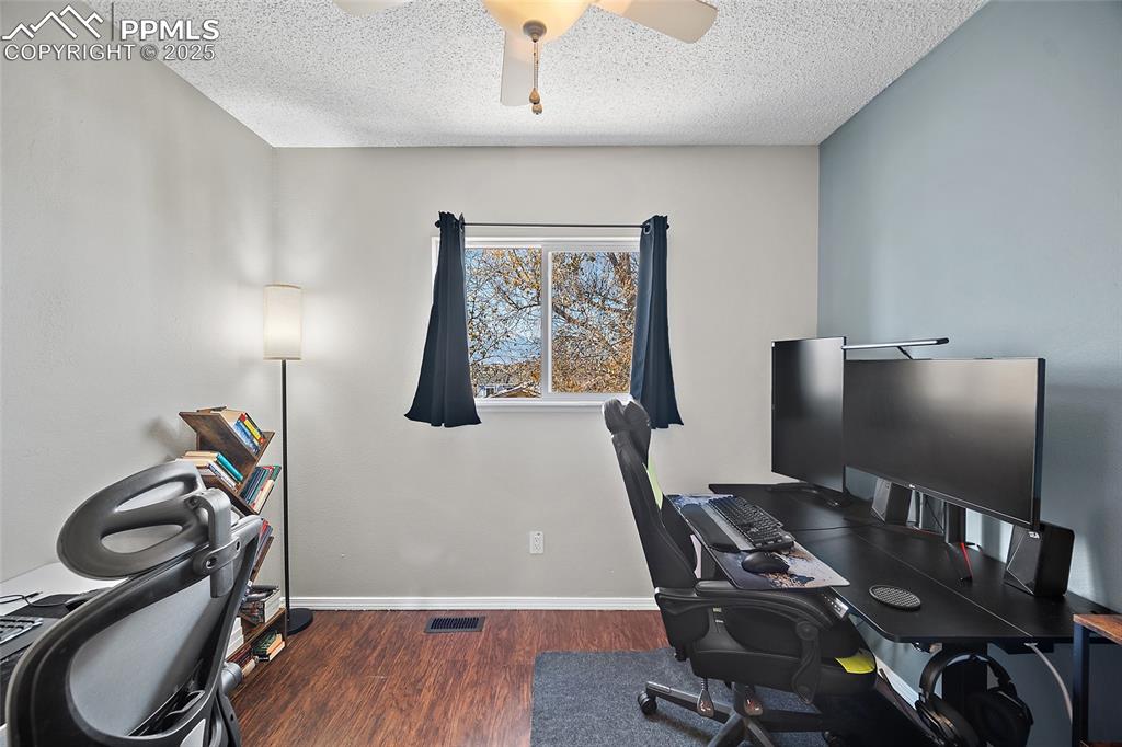 Image 22 of 50: Office area featuring dark wood finished floors, a textured ceiling, and ce