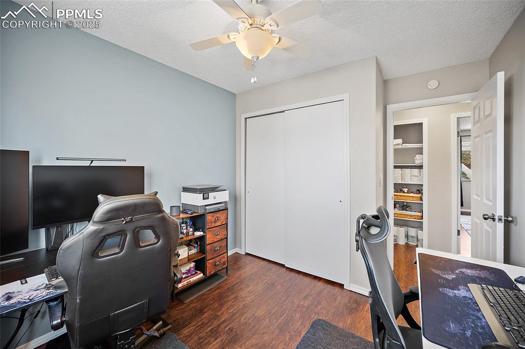 Image 24 of 50: Office featuring a textured ceiling, dark wood-style flooring, and ceiling 