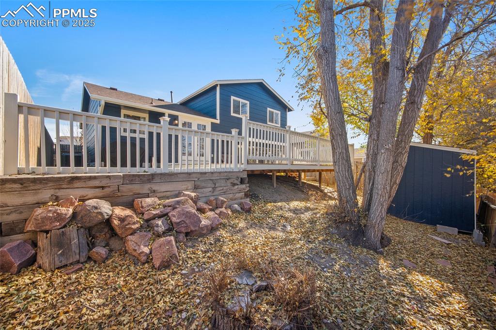 Image 35 of 50: Rear view of house featuring a deck and an outdoor structure