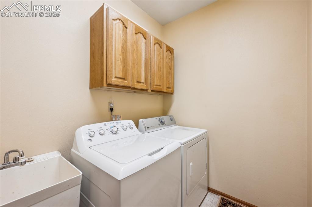 Image 23 of 43: Laundry room featuring washing machine and dryer and cabinet space