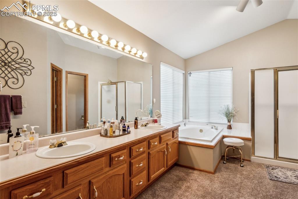 Image 27 of 43: Full bathroom with a shower stall, a garden tub, double vanity, lofted ceil