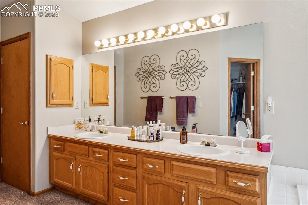 Image 29 of 43: Full bathroom featuring double vanity and a walk in closet