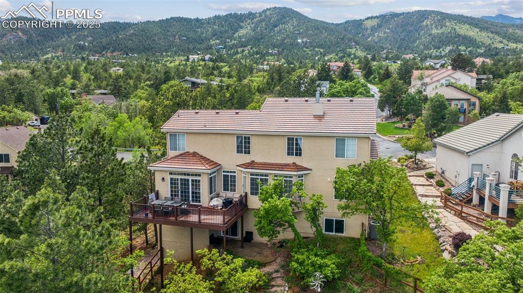 Image 3 of 43: Back of house with stucco siding, a tiled roof, and a deck with mountain vi