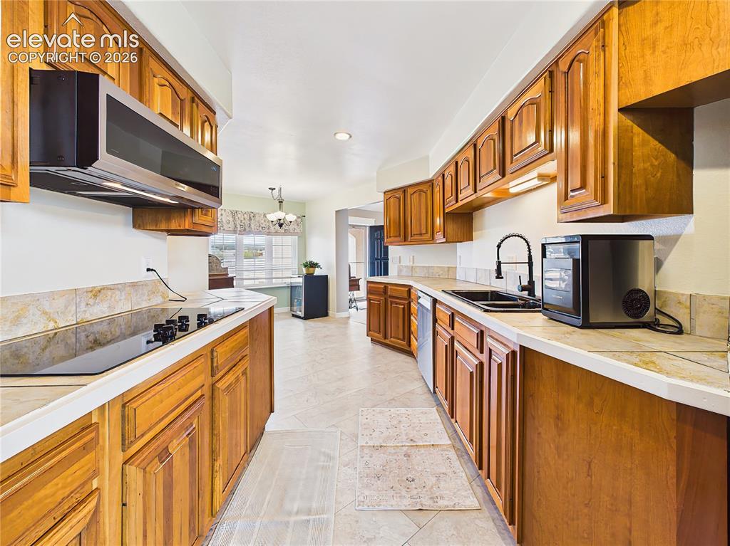 Image 11 of 50: Bright and functional kitchen features abundant storage, expansive countert