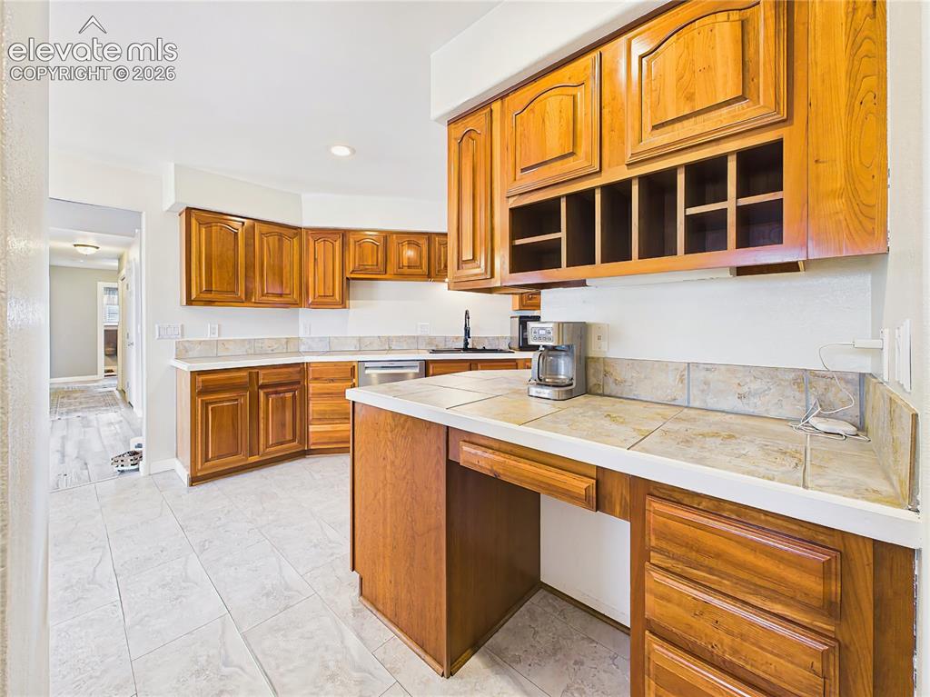 Image 12 of 50: Functional butler’s pantry offers extensive cabinetry, generous counter spa
