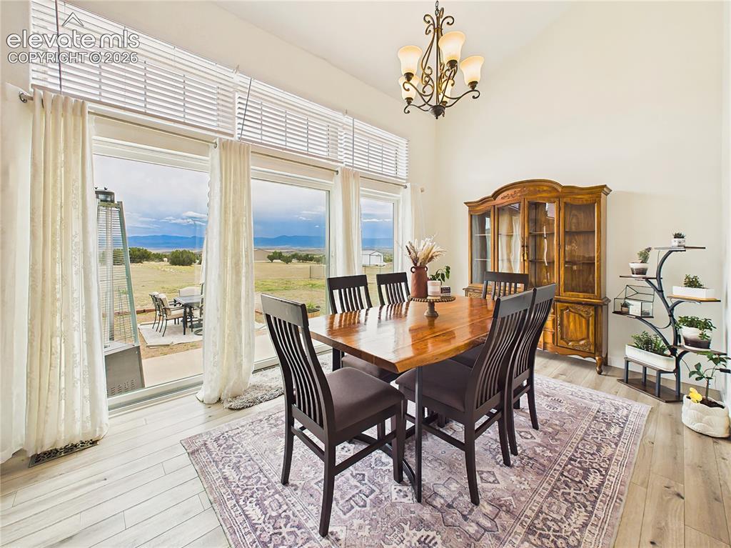Image 15 of 50: Expansive windows provide a stunning backdrop for dining, seamlessly connec