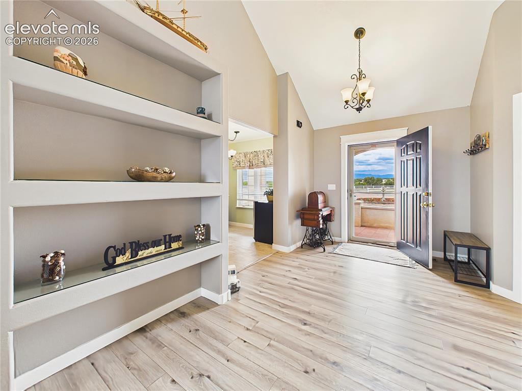 Image 16 of 50: Welcoming foyer features vaulted ceilings, updated flooring, and custom bui