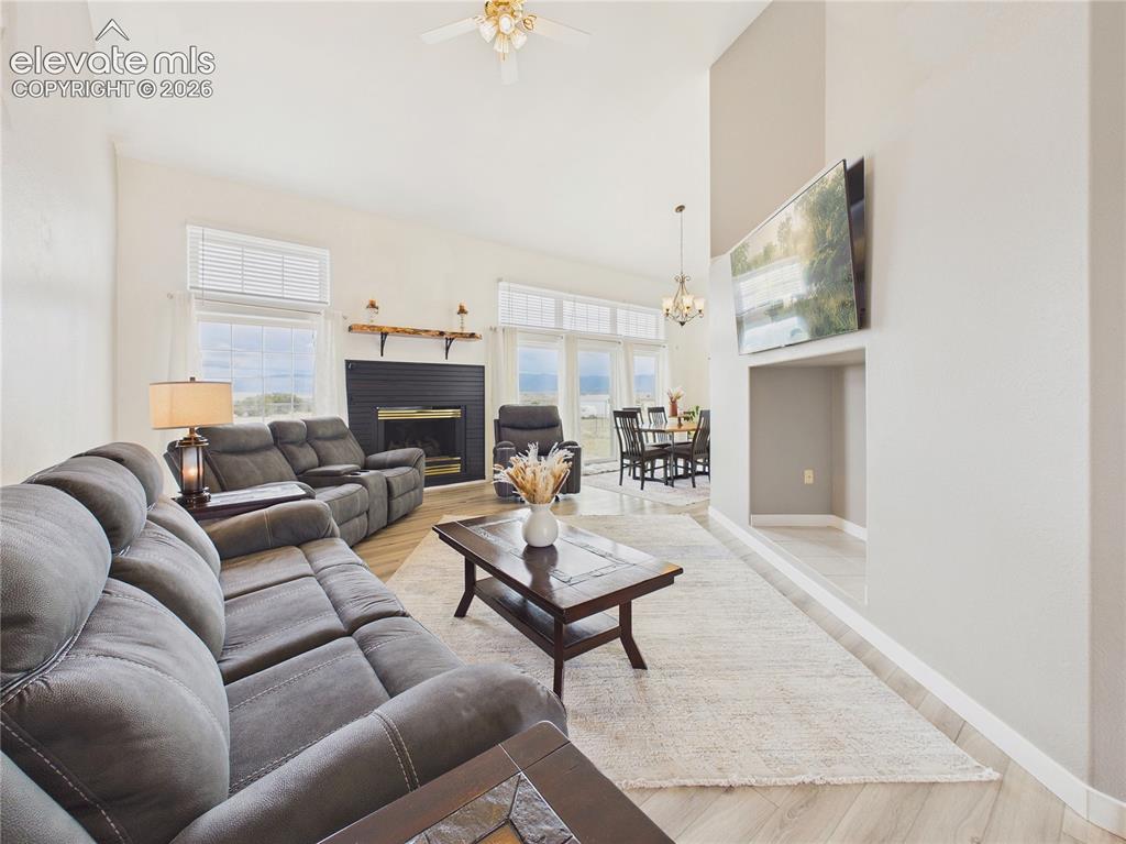 Image 17 of 50: Bright and inviting living room features soaring vaulted ceilings, updated