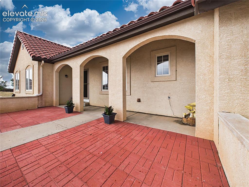Image 2 of 50: Inviting front porch features arched architectural details and ample space