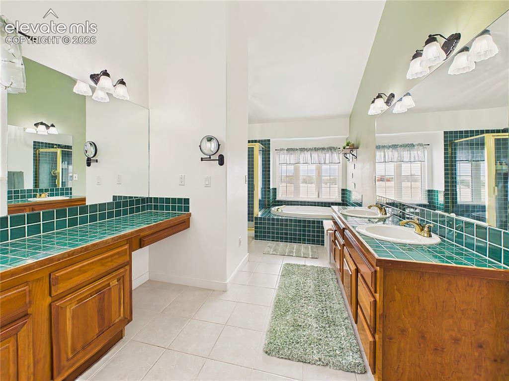 Image 24 of 50: Generously sized 5-piece primary bath with dual vanities, extensive counter