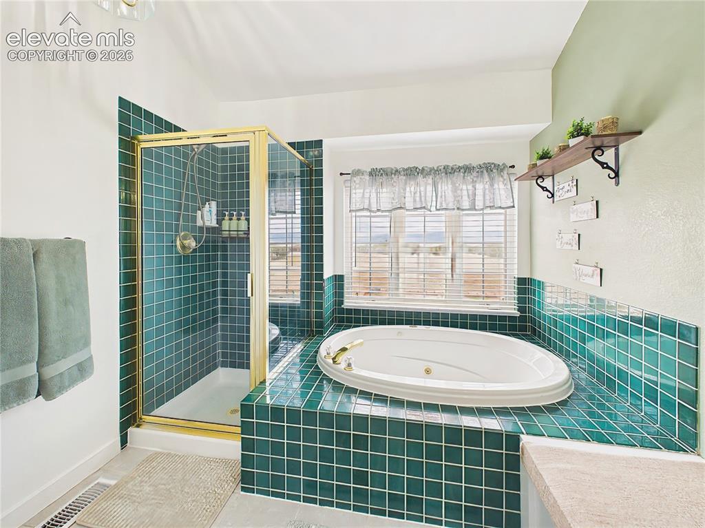 Image 25 of 50: Spa-inspired bath includes a soaking jetted tub, separate shower, and large