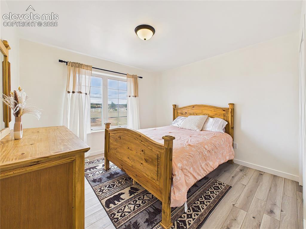 Image 27 of 50: Comfortable main level bedroom 2 with ample closet space, updated flooring,