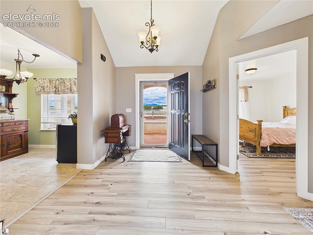 Image 3 of 50: Welcoming entryway features vaulted ceilings, updated flooring, and an open