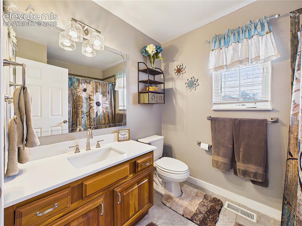 Image 31 of 50: Updated hall bathroom features a modern vanity, stylish fixtures, and conve