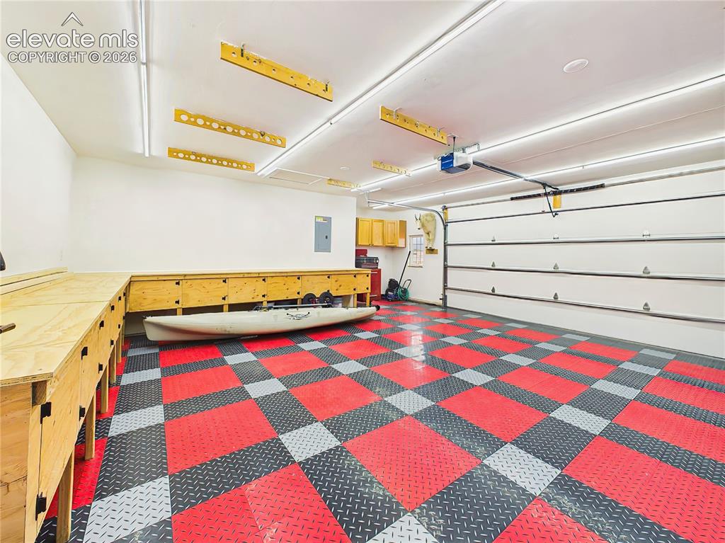 Image 36 of 50: Oversized garage is thoughtfully outfitted with custom built-in workbenches