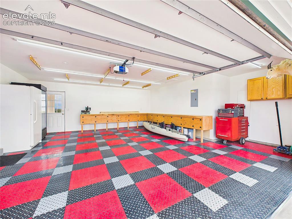 Image 37 of 50: Exceptional oversized garage features custom workbenches, extensive storage