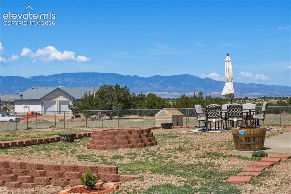Image 47 of 50: Backyard patio and firepit area offer an inviting space for evening gatheri