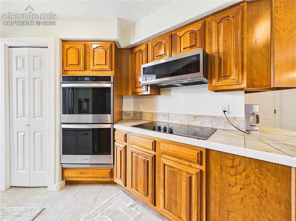 Image 8 of 50: Stainless steel double wall ovens, modern cooktop, and plentiful cabinetry