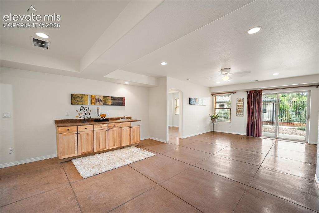 Image 21 of 40: Basement family room with wet bar and walks out.