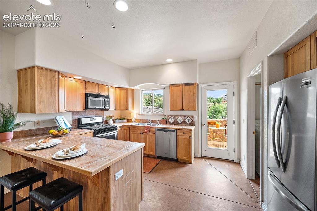 Image 9 of 40: Kitchen walks out to balcony patio.