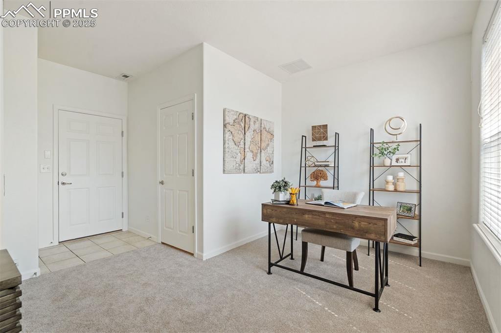 Image 9 of 43: Entry-level flex space with access to the 1/2 bathroom and garage - ideal f