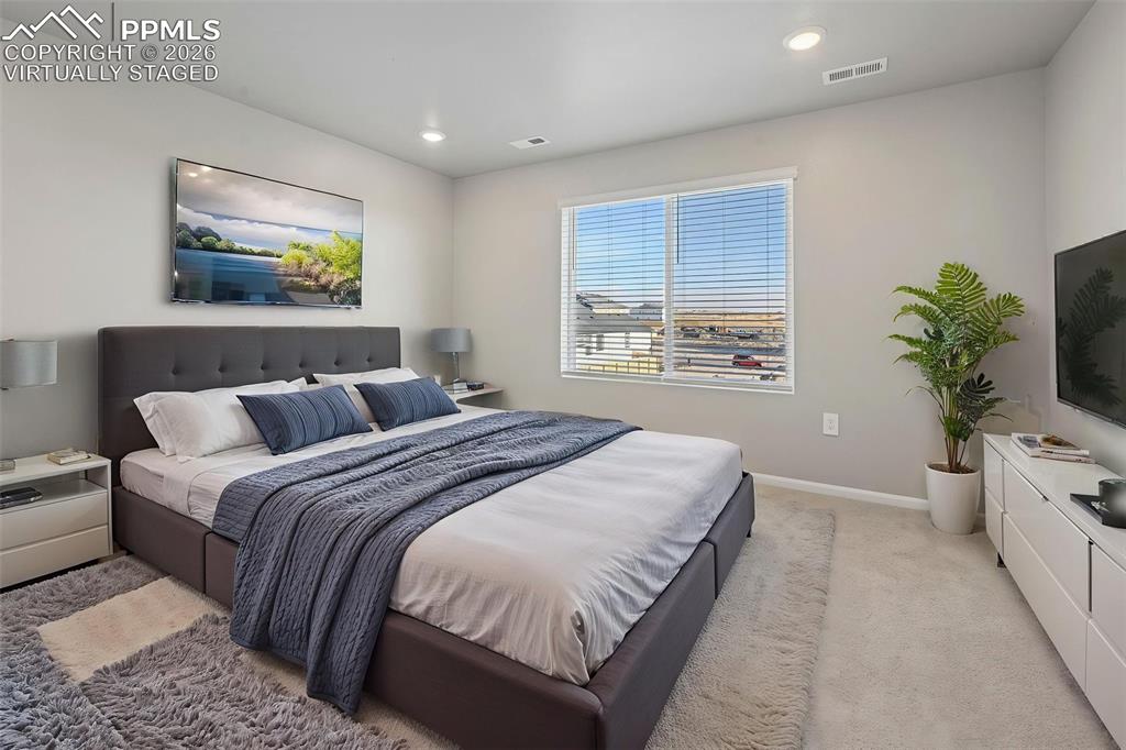 Image 18 of 39: Virtually staged primary bedroom w/ ensuite 